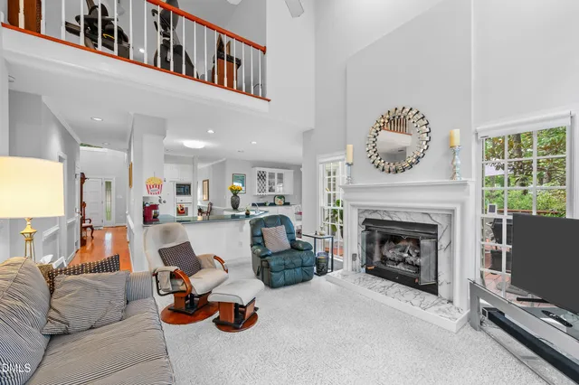 a living room with furniture a fireplace and a large window