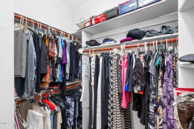 a view of walk in closet with clothes