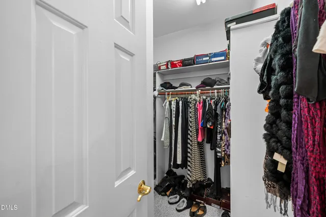 a view of walk in closet with clothes