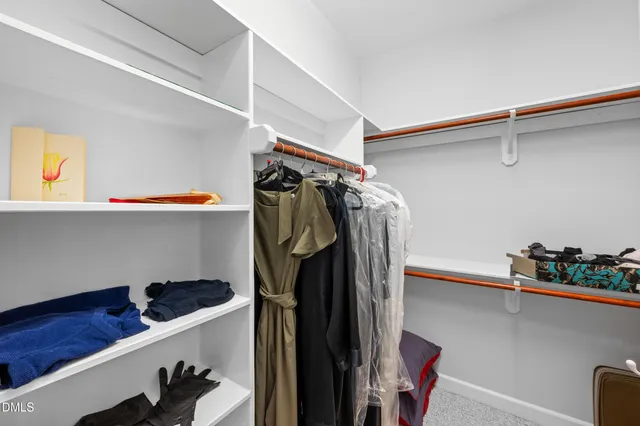 a view of walk in closet with clothes and shoes
