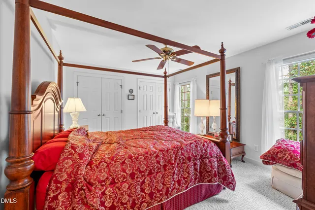 a bed sitting in a bedroom next to a window