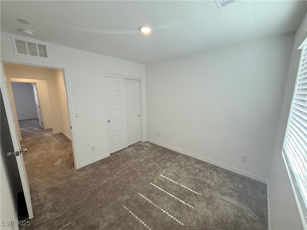 10772 Astell Isle Court Las Vegas, NV 89166 - Photo 20 of 32 Unfurnished bedroom with dark colored carpet and a closet