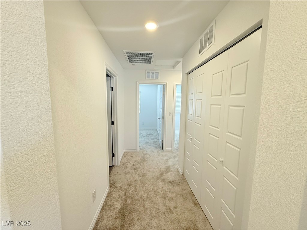 10772 Astell Isle Court Las Vegas, NV 89166 - Photo 21 of 32 Hallway featuring a textured wall and light colored carpet