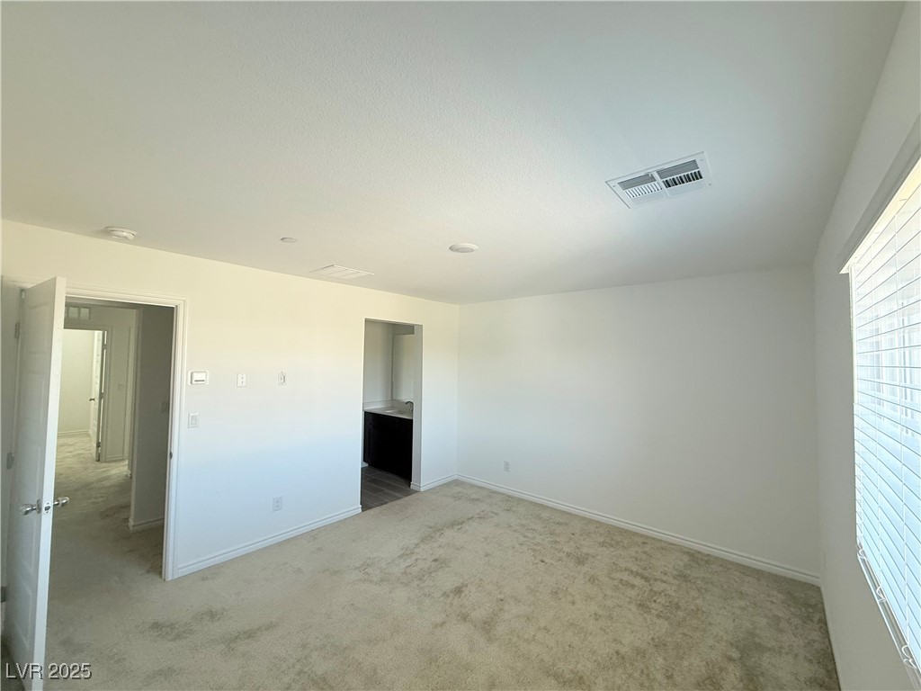 10772 Astell Isle Court Las Vegas, NV 89166 - Photo 24 of 32 Primary bedroom with light carpet and baseboards