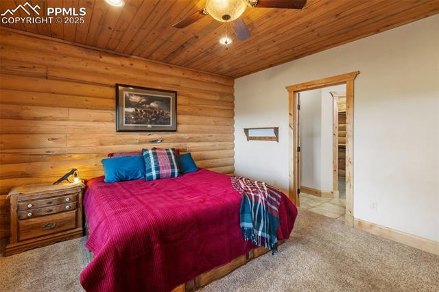111 Blue Spruce Road Divide, CO 80814 - Photo 23 of 46 Carpeted bedroom featuring log walls, wooden ceiling, ceiling fan, and recessed lighting