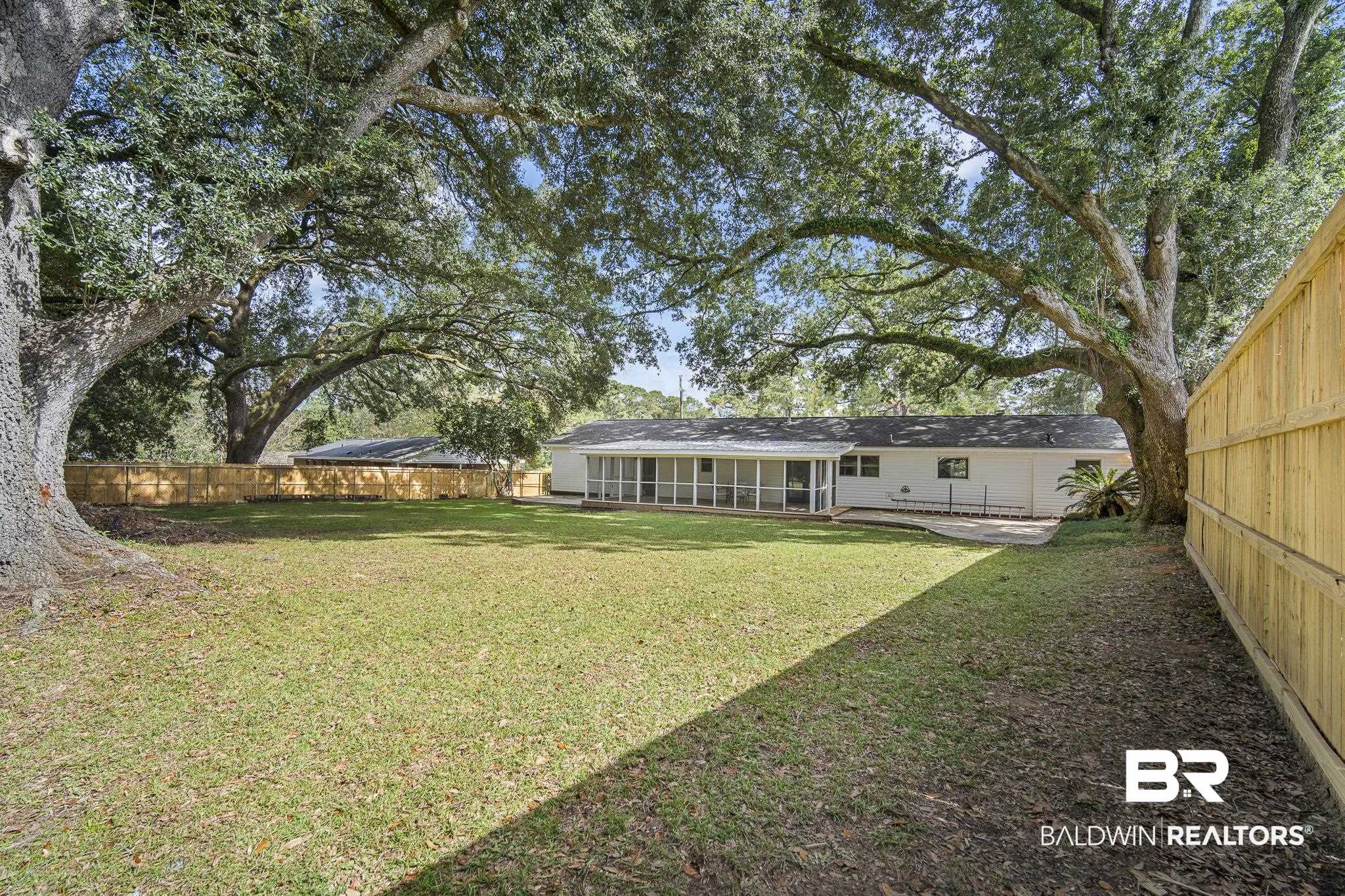 103 Ann Street Daphne, AL 36527 - Photo 21 of 23 Fenced backyard with a sunroom and a patio area