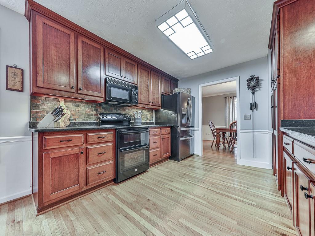 1108 Fieldstone Drive Canton, GA 30114 - Photo 14 of 40 a kitchen with stainless steel appliances granite countertop wooden cabinets a stove top oven a sink and dishwasher