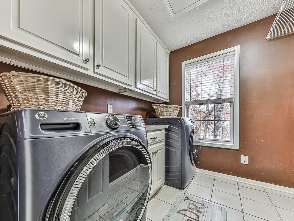 1108 Fieldstone Drive Canton, GA 30114 - Photo 32 of 40 a view of washer and dryer with kitchen in the background