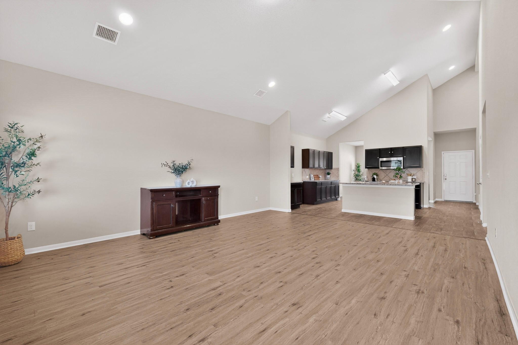 5905 Diamondleaf Bend Austin, TX 78724 - Photo 8 of 38 Expansive open-concept living area featuring wood-finish flooring and vaulted ceilings