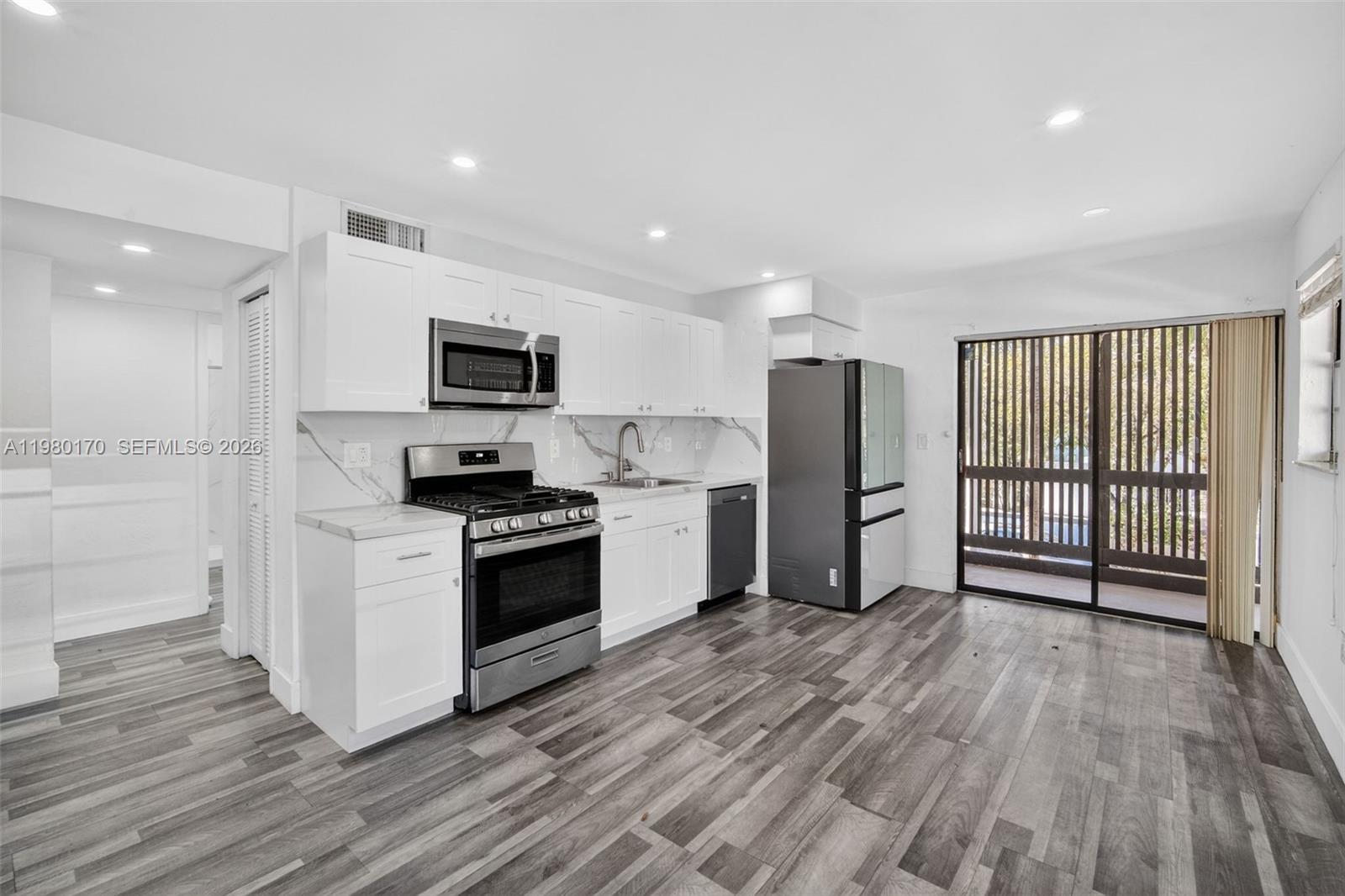 3265 Virginia Street, Unit 25 Miami, FL 33133 - Photo 12 of 28 a kitchen with stainless steel appliances a stove top oven a sink and a refrigerator