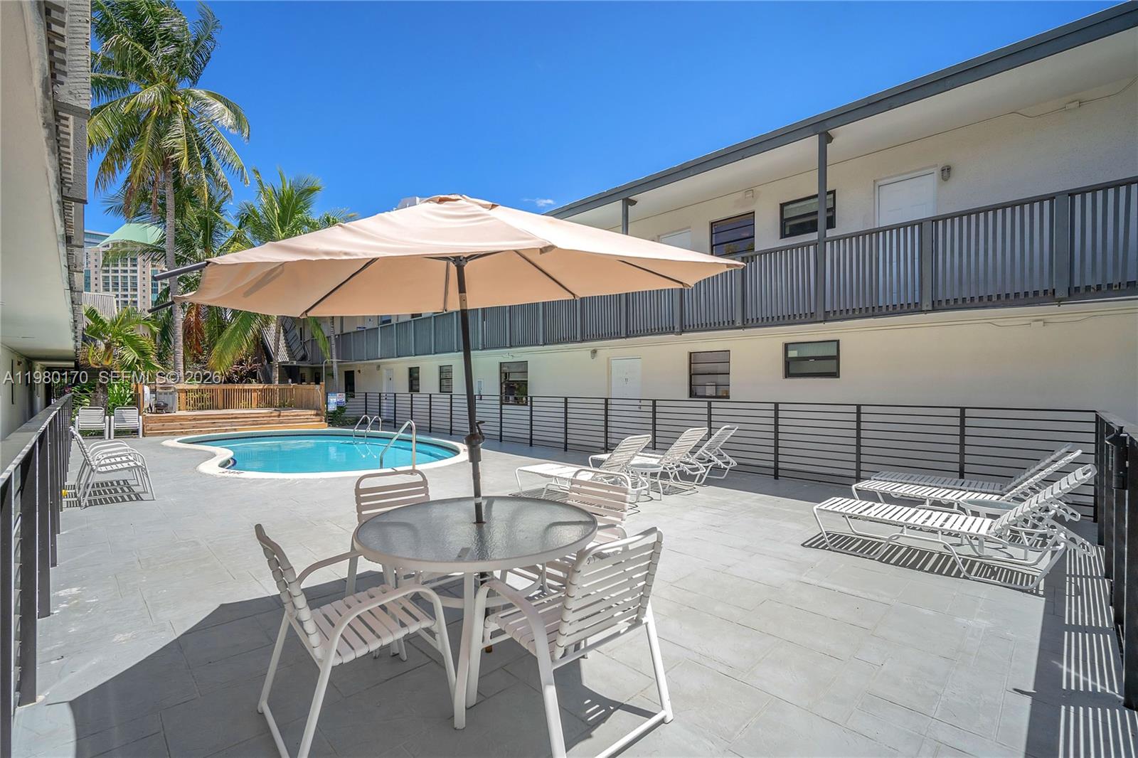 3265 Virginia Street, Unit 25 Miami, FL 33133 - Photo 26 of 28 a patio with a table and chairs under an umbrella