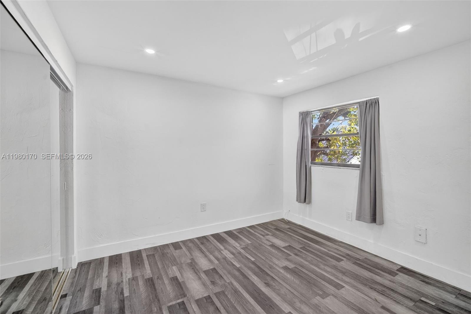 3265 Virginia Street, Unit 25 Miami, FL 33133 - Photo 5 of 28 a view of empty room with wooden floor and fan