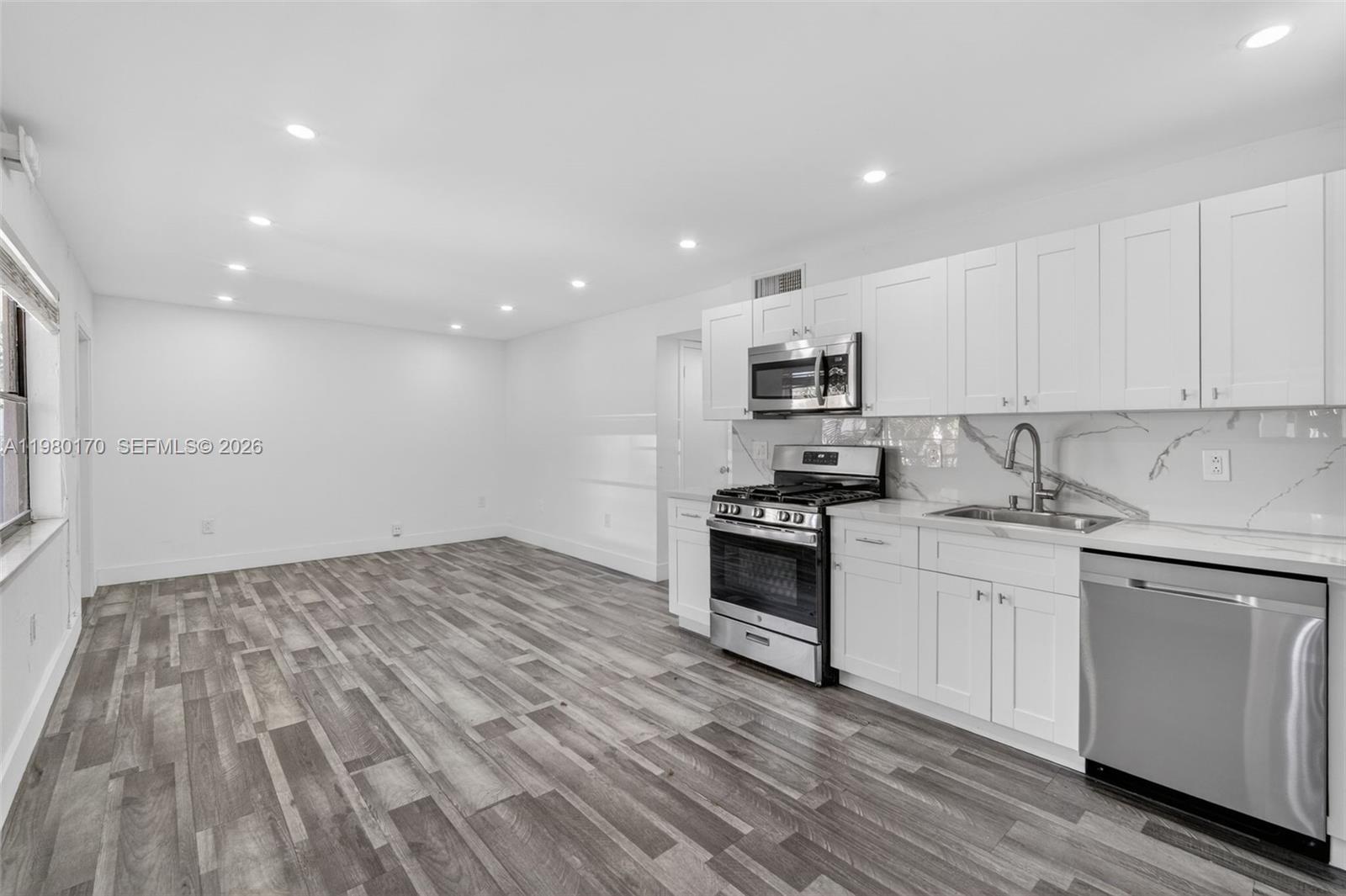 3265 Virginia Street, Unit 25 Miami, FL 33133 - Photo 8 of 28 a kitchen with granite countertop a sink stove and cabinets