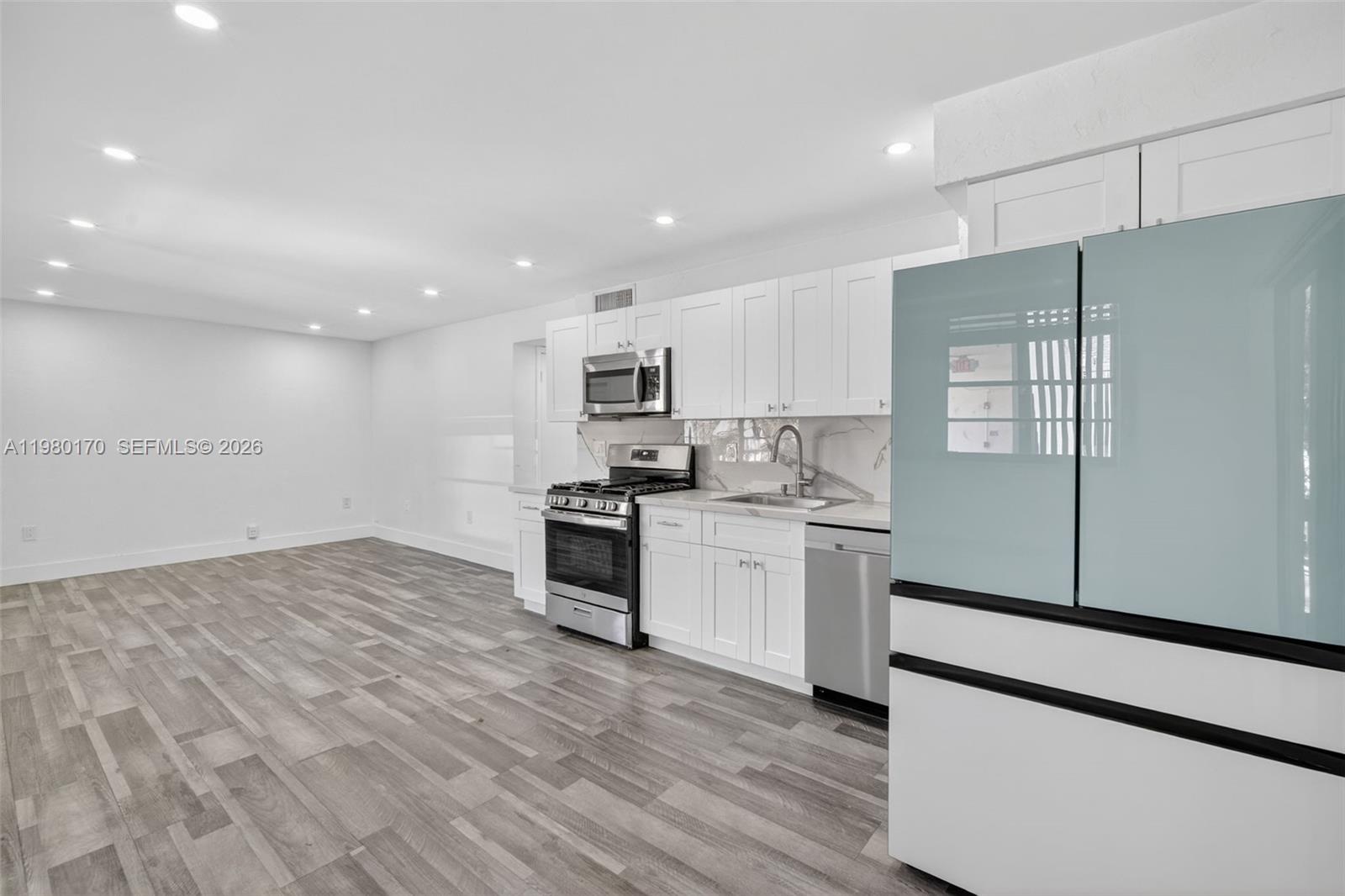 3265 Virginia Street, Unit 25 Miami, FL 33133 - Photo 9 of 28 a kitchen with granite countertop a refrigerator stove top oven and sink