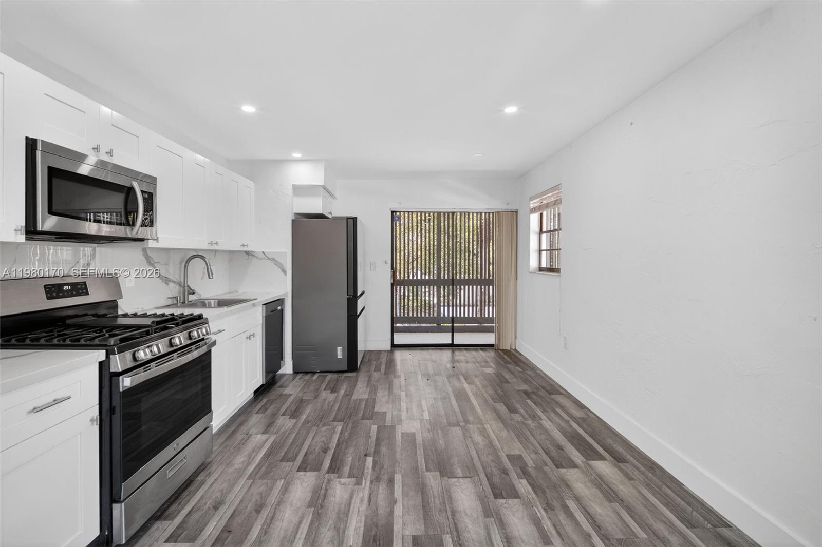 3265 Virginia Street, Unit 25 Miami, FL 33133 - Photo 10 of 28 a kitchen with stainless steel appliances granite countertop a stove a sink and a refrigerator
