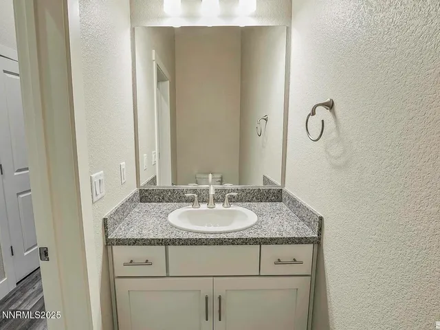 a bathroom with a granite countertop sink and a mirror