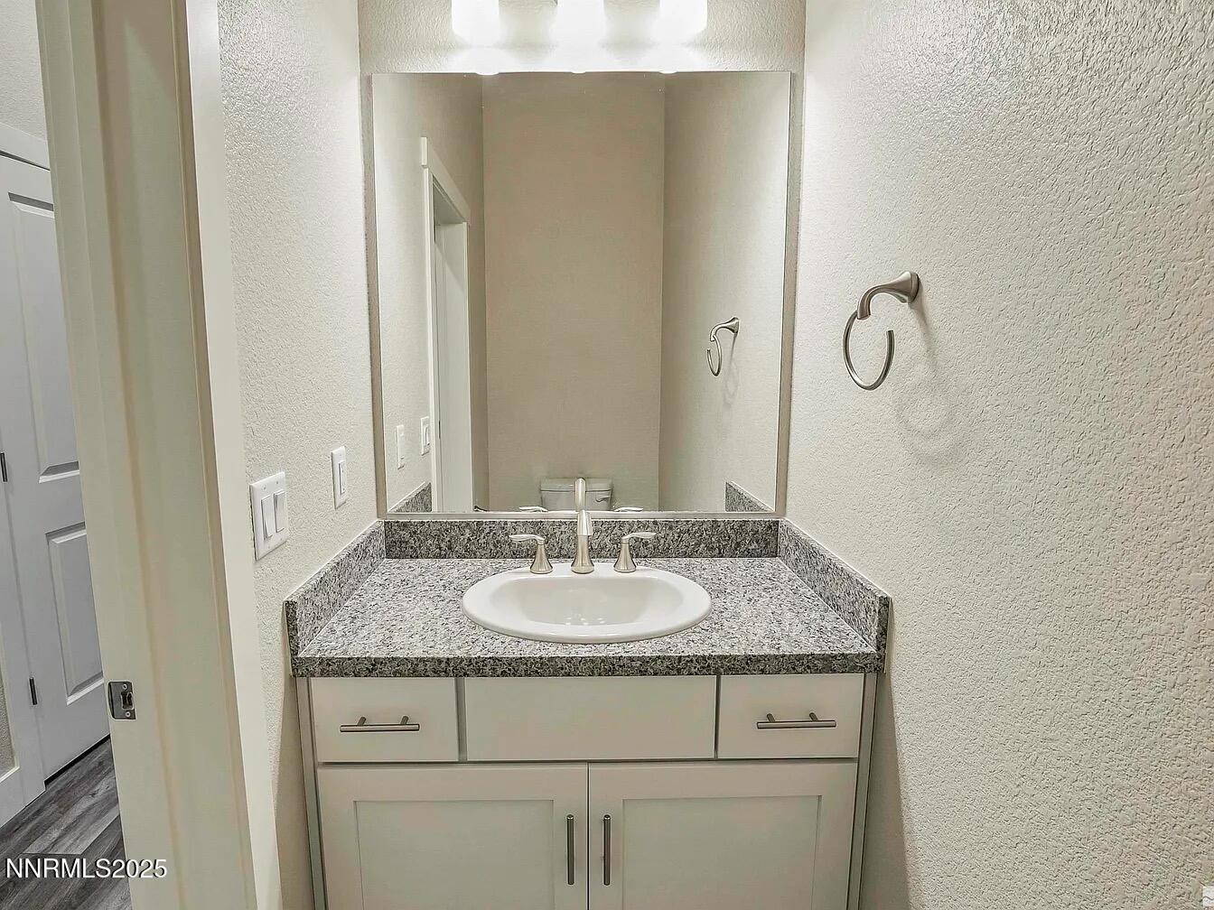 455 Axelson Way Genoa, NV 89411 - Photo 11 of 30 a bathroom with a granite countertop sink and a mirror