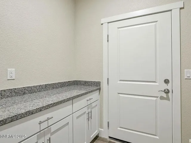a view of a storage and utility room with granite countertop cabinets