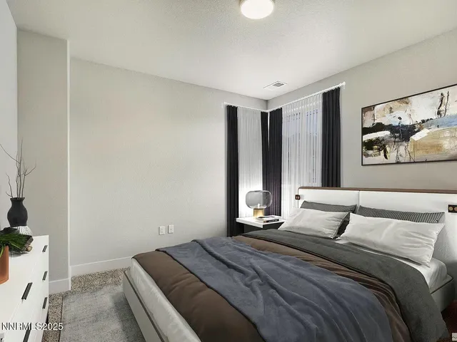 a bedroom with a large bed and a painting on the wall