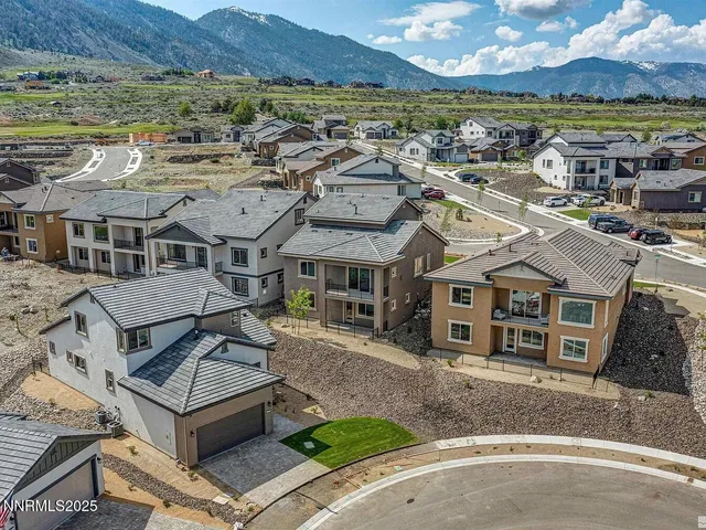 an aerial view of residential houses with outdoor space and ocean view