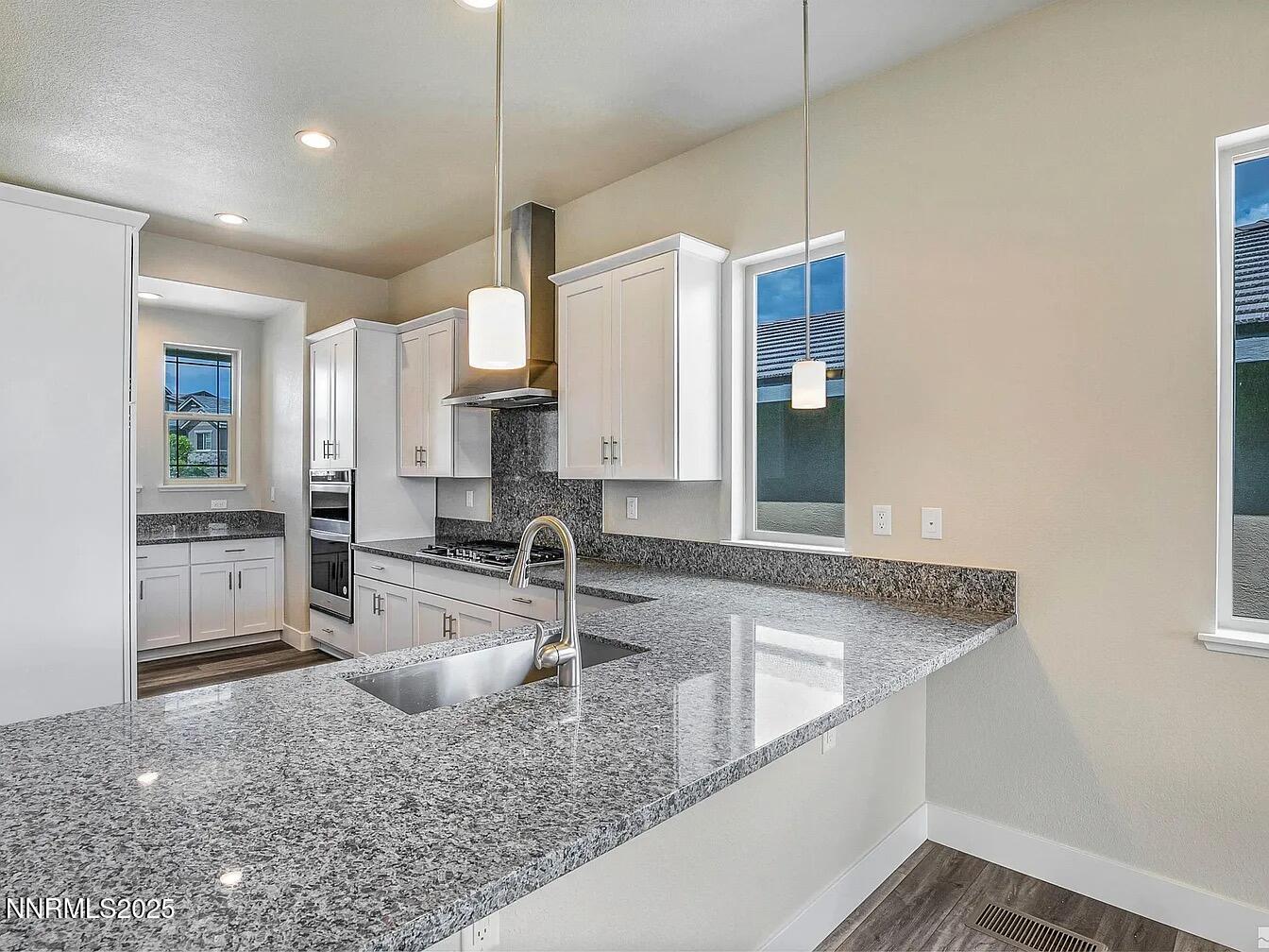 455 Axelson Way Genoa, NV 89411 - Photo 9 of 30 a kitchen with stainless steel appliances granite countertop a sink a stove and a refrigerator