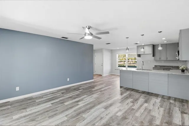 a kitchen with granite countertop a stove a sink and a refrigerator