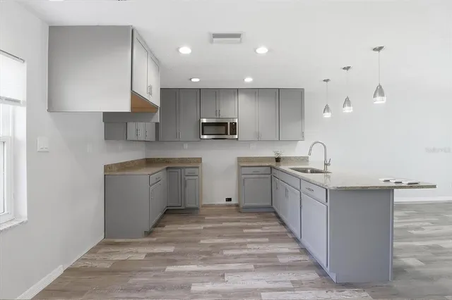 a kitchen with granite countertop a sink stove top oven and cabinets