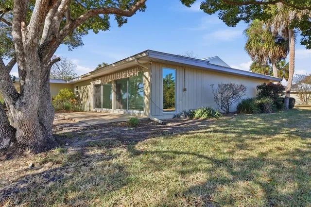 a view of a house with backyard and a tree