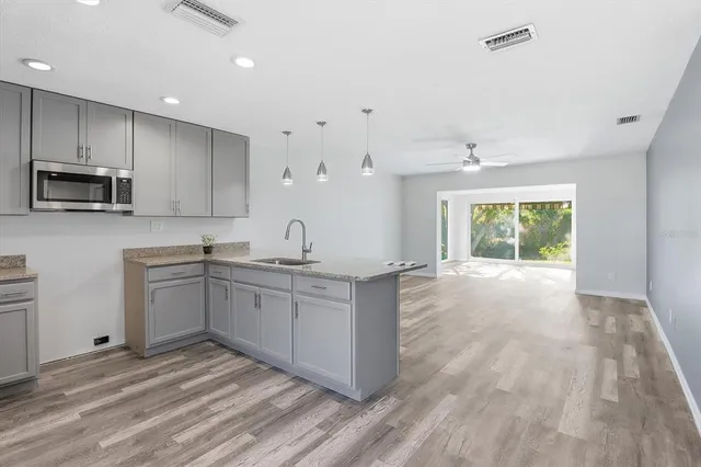 a kitchen with granite countertop a stove top oven sink and cabinets