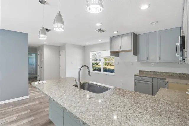 a kitchen with kitchen island a sink appliances and cabinets