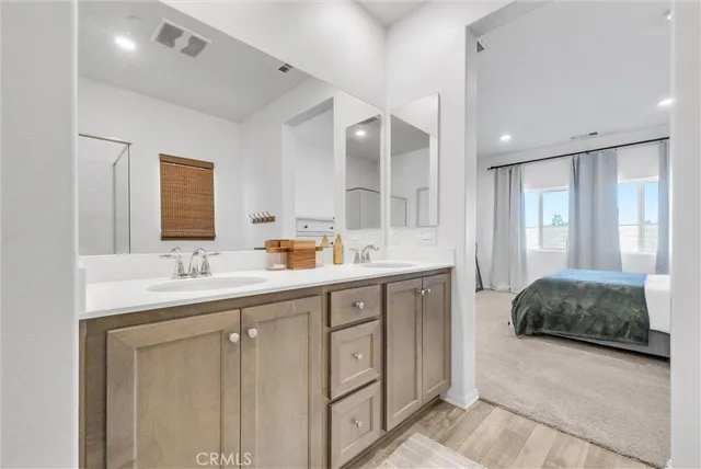 a spacious bathroom with a double vanity sink a mirror and a shower
