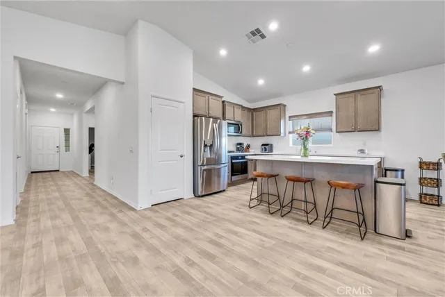 a kitchen with stainless steel appliances kitchen island granite countertop a refrigerator and a stove top oven