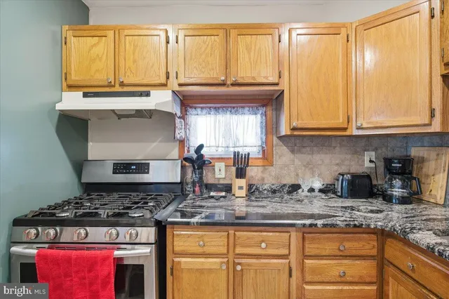 a kitchen with granite countertop a stove a sink and a granite counter tops