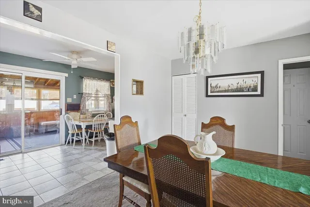 a dining room with furniture a chandelier and wooden floor