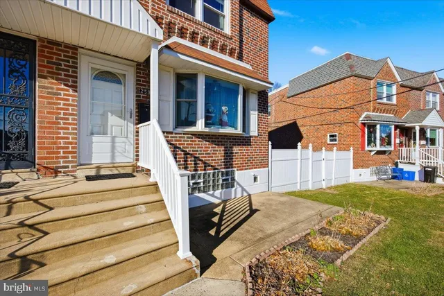 a view of a white house with swimming pool and wooden fence