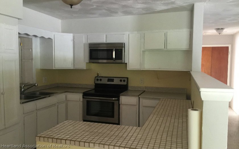 3905 Lakewood Road Sebring, FL 33875 - Photo 2 of 18 a kitchen with a stove and a microwave