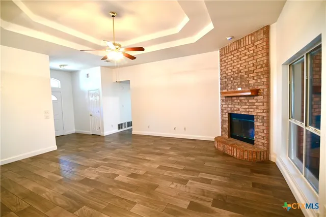 a view of an empty room with a fireplace and a window