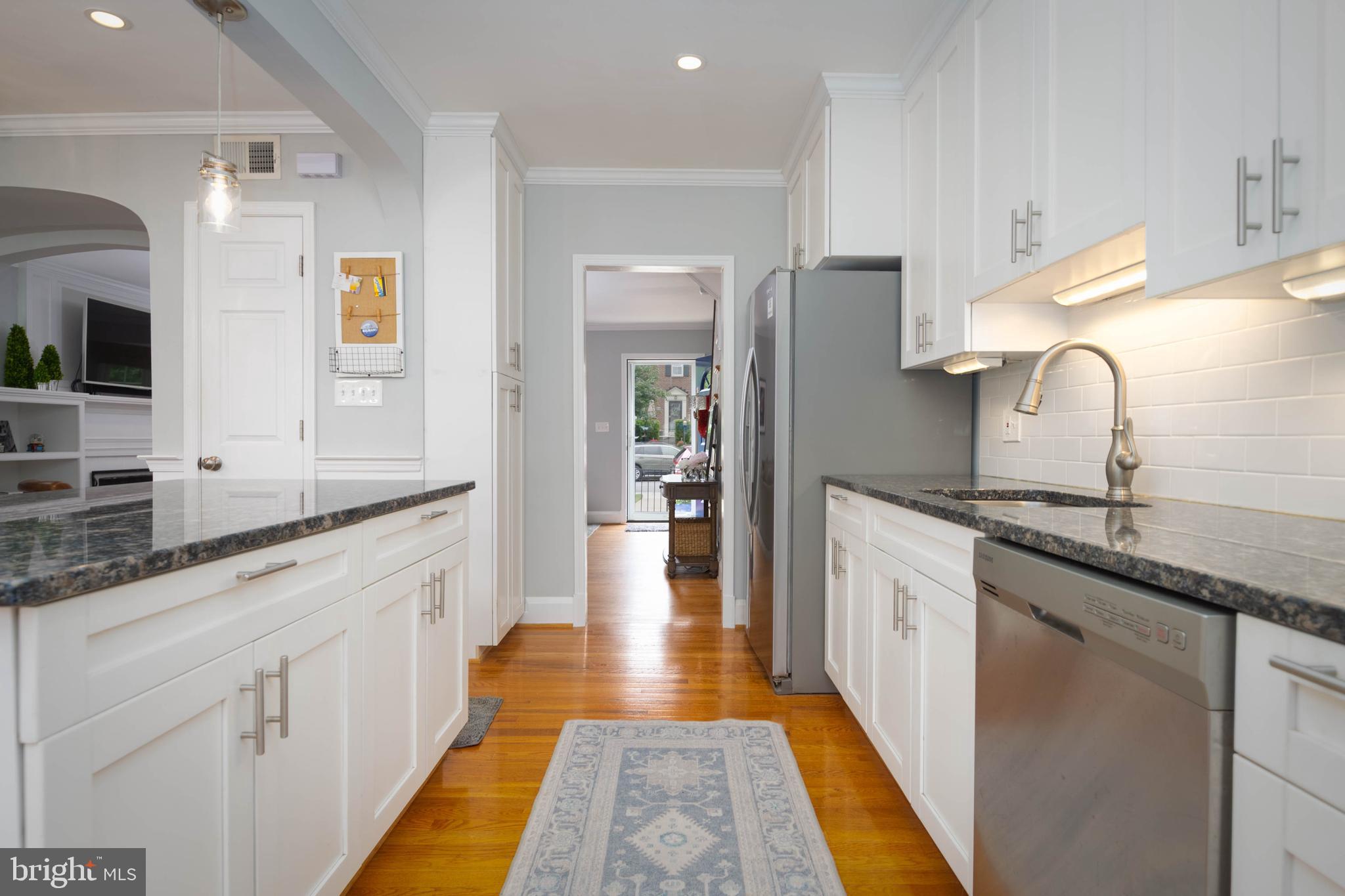 409 Regester Avenue Baltimore, MD 21212 - Photo 17 of 44 a large kitchen with stainless steel appliances granite countertop a sink and dishwasher a stove with wooden floor