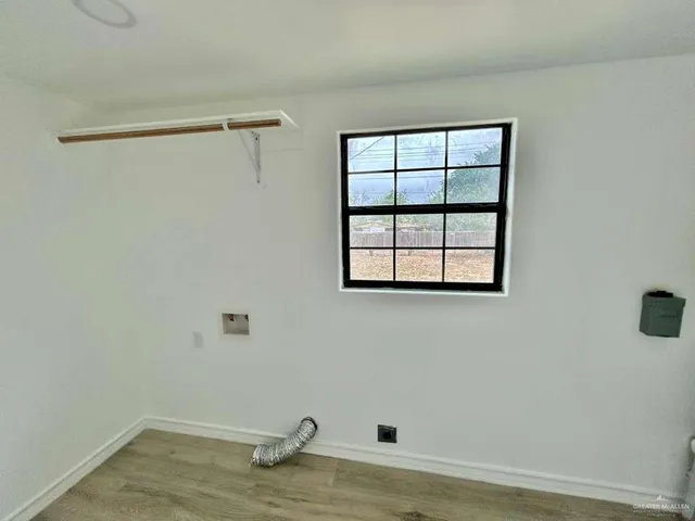 a view of a small space with wooden floor and a window