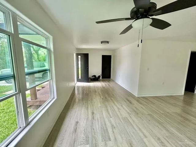 a view of hallway with wooden floor and chandelier