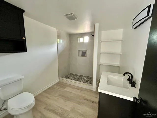 a bathroom with a sink a toilet a shower and a mirror