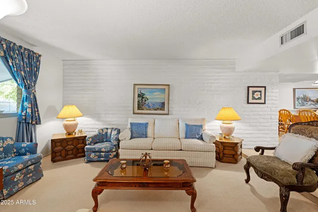 a living room with furniture a table and a potted plant