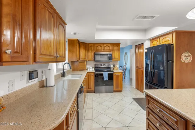 a kitchen with stainless steel appliances granite countertop a sink a stove and a refrigerator