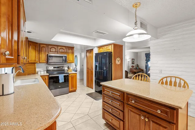 a kitchen with stainless steel appliances a stove a sink a refrigerator and a refrigerator