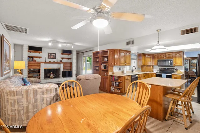 a view of a dining room with furniture a kitchen and chandelier
