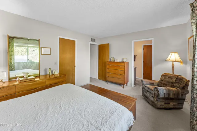 a bedroom with a bed and dresser with mirror