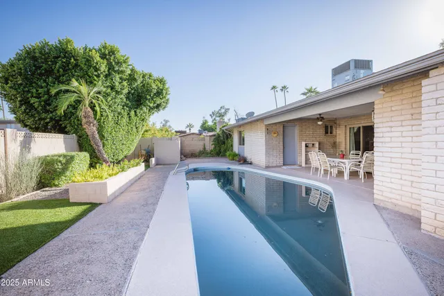 a view of a house with pool and sitting area