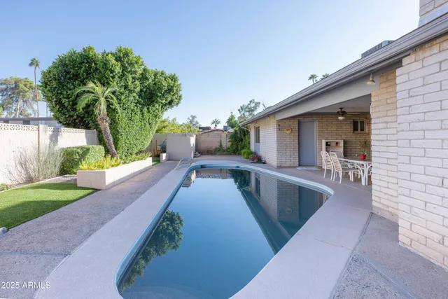 a view of a house with backyard and sitting area