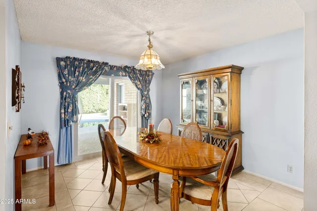 a dining room with furniture a chandelier and window