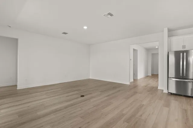 a view of empty room with wooden floor and appliances